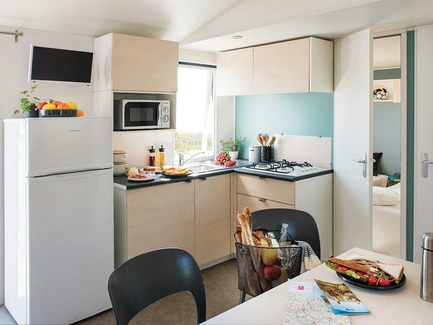 Cuisine équipée de mobil home du camping les 7 saints à Erdeven avec une table et des chaises